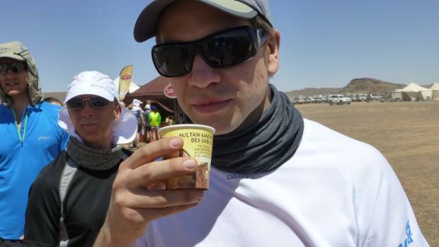 Jakob sampling Sultan's sponsor tea, a sugary sweet tea we were served every time we passed the finish line